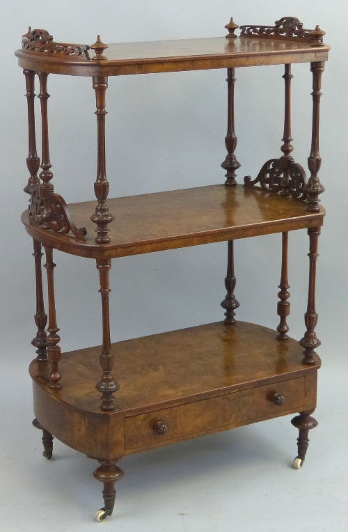 A Victorian walnut whatnot, comprising three oval tiers on baluster turned and reeded supports