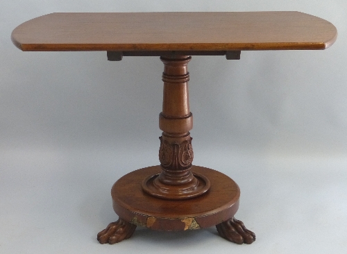 A  William IV mahogany breakfast table, the rounded oblong top on turned stem with carved stiff leaf