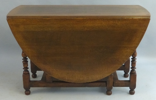 A 19th Century oak gate leg dining table, the oval top with shaped frieze opposing a frieze