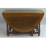 A 19th Century oak gate leg dining table, the oval top with shaped frieze opposing a frieze