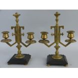 A pair of brass candelabra, possibly Russian, each with central turned stem supporting two angular