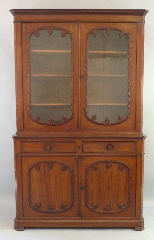 A 19th Century mahogany bookcase on cabinet, having stepped cornice over two glazed doors