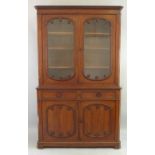 A 19th Century mahogany bookcase on cabinet, having stepped cornice over two glazed doors