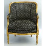 An early 20th Century gilded gesso framed bergere armchair, having beaded and line moulded frame and