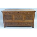 A 19th Century oak chest, the moulded edged hinged lid over panelled fascia carved with stylised