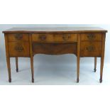 A late 19th/early 20th Century mahogany sideboard, of serpentine form with central frieze drawer,