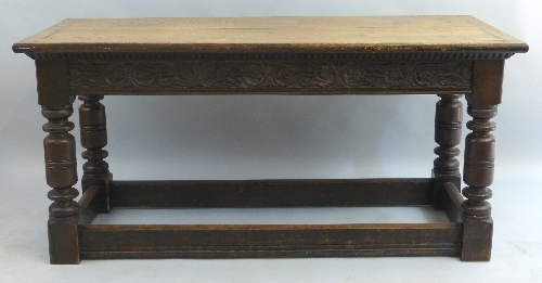 A 19th Century oak refectory table, the oblong top over scroll carved frieze on turned and block