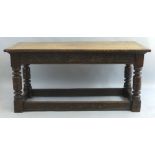 A 19th Century oak refectory table, the oblong top over scroll carved frieze on turned and block