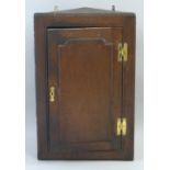 A 19th Century oak corner cupboard, wall hanging with panelled door enclosing shelves, 76cm high,