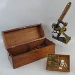 A brass monocular microscope by R & J Beck London, the cast triangular base with hinged strut