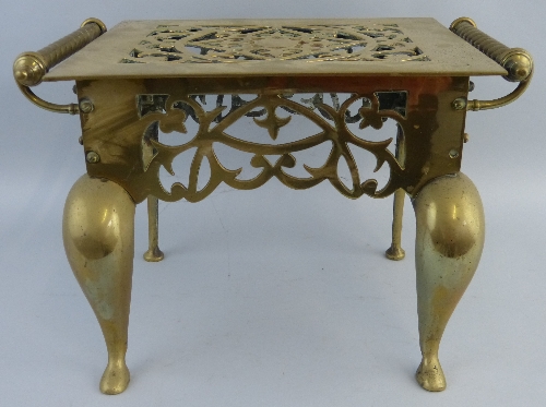 A 19th Century brass footman, the pierced oblong top with two rope twist carrying handles over a