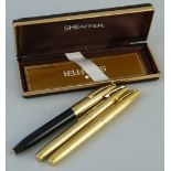 Three Sheaffer fountain pens, two with gold plated cases, the other with a black case in Sheaffer