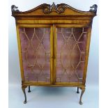 A 19th Century mahogany display cabinet, with scroll carved pediment over a pair of eighteen panel