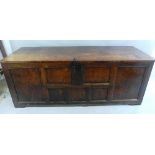 A late 17th/18th Century oak chest, with later plain planked top, seven panel fascia and panelled