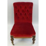 A Victorian oak framed nursing chair, with button upholstered back, overstuffed seat on carved,