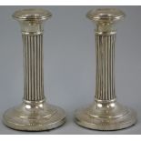 A pair of Edwardian candlesticks, with slightly dished tapering sconces on reeded circular columns