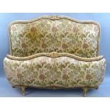 A 20th Century French double bed, the floral upholstered headboard with painted carved and
