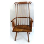 An ash and elm comb back Windsor chair, with curved crest rail, turned stick supports and four plain