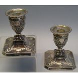 A pair of Victorian dwarf candlesticks, each with beaded circular drip pan and urn shaped sconce