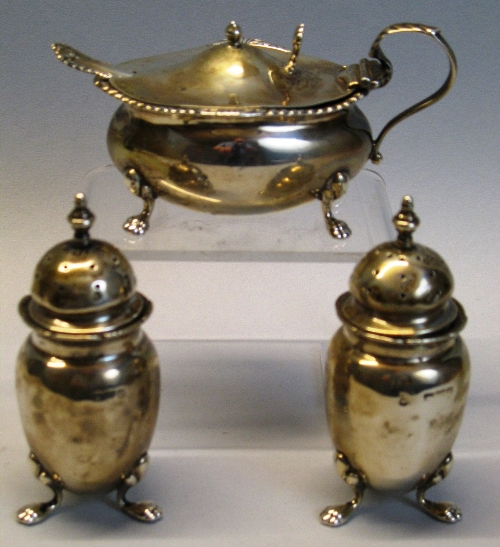 A Victorian three piece condiment set, the lozenge shaped bombe mustard pot with turned finial and