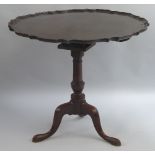 A 19th Century mahogany tripod table, the circular tilt top with Chippendale moulded rim on bird