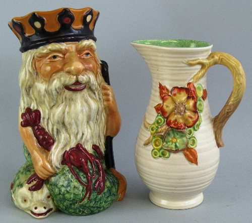 A Newport Pottery jug, of ribbed baluster form moulded with flowerheads and leaves and scrolling