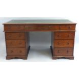 A mahogany pedestal desk, having leather writing surface over three frieze drawers on two banks of