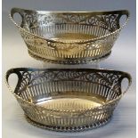 A graduated pair of continental white metal baskets, each of tapering oval form with two aperture
