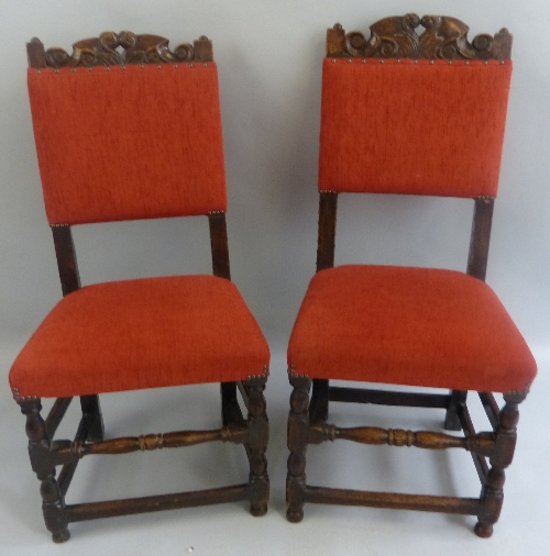 A near pair of oak hall chairs, late 17th/early 18th Century, each with scroll carved and pierced