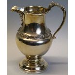 A cream jug, of pedestal baluster form with chased Celtic style band and lip and dragon mounted