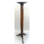 A Victorian mahogany torchere, with circular top, turned and carved wrythen stem and three