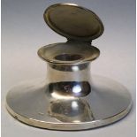 An Edwardian capstan inkwell, of typical form, the slightly domed hinged lid opening to reveal a