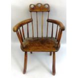 A country made yew wood and elm armchair, with arcaded and pierced crest rail over a stick back