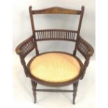 An Edwardian mahogany side chair, with urn inlaid crest rail over a central bar of turned sticks,