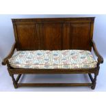 A 19th Century oak settle, the raised back with three fielded panels over a later planked seat,