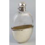 A Victorian hip flask, of oval clear glass form with hinged domed top and removable beaker cover,