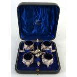 A set of four Indian white metal salts, each of tapering circular form with blue glass liners, the