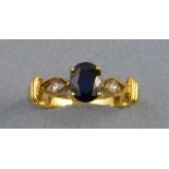 A sapphire and diamond ring, with central oval sapphire on .750 gold shank with pierced shoulders