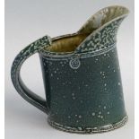 Walter Keeler, a salt glazed stoneware jug with ridged strap work handle and blue/green finish,