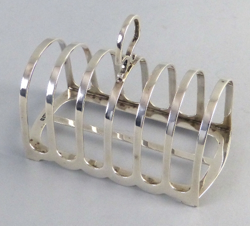 An Edwardian toast rack, with seven arched bars and loop handle, 12.5cm wide Sheffield 1909 4.75ozs
