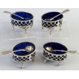 A set of four George III salts, each of oval shape with gadroon rim, pierced sides, blue glass