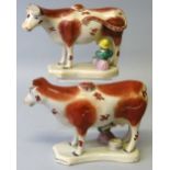 A pair of 19th century Staffordshire cow creamers and milk maid groups, with lids, each with brown