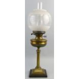 A table oil lamp, with ebonised wooden square base brass reeded column stem and reservoir, duplex