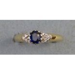 A sapphire and diamond ring, comprising central oval sapphire, flanked by six diamonds to each