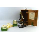 A mid 20th century monocular steel microscope by Prior London, with black painted finish and rise-