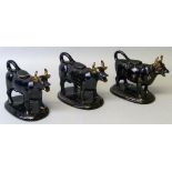 Three 19th century Staffordshire black glazed cow creamers, each with tail loop handle and lid and