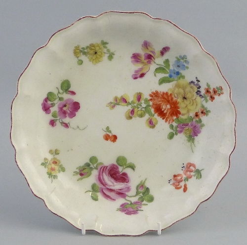 An 18th century dish in the Chelsea style, of shallow circular form with wavy rim, the centre
