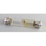 A Victorian double ended perfume bottle, the facetted clear glass body with unmarked white metal