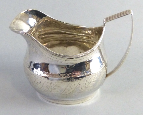 A George III cream jug, of bulbous shape with reeded rim and angular handle, 9.5cm high, London