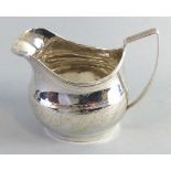 A George III cream jug, of bulbous shape with reeded rim and angular handle, 9.5cm high, London